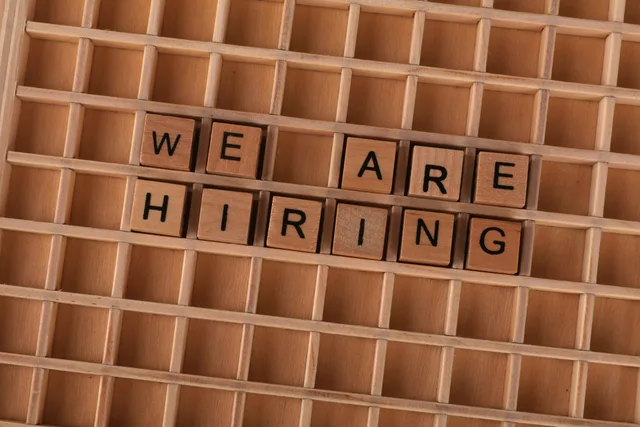 Wooden tiles on a board forming the phrase 'We Are Hiring', ideal for job announcements. Employer branding tool implementation explained for hiring teams